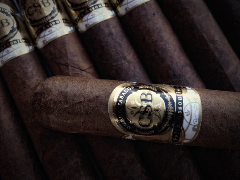 A CSB Habano cigar resting across a row of CSB cigars