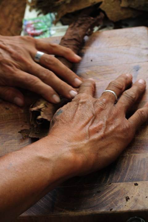 A roller's hands smoothing the wrapper