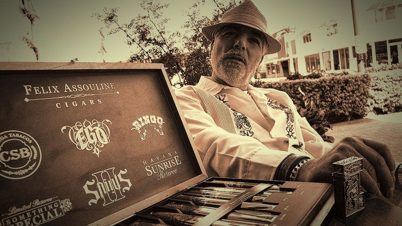 Felix Assouline at the farm, holding an open box of his cigars