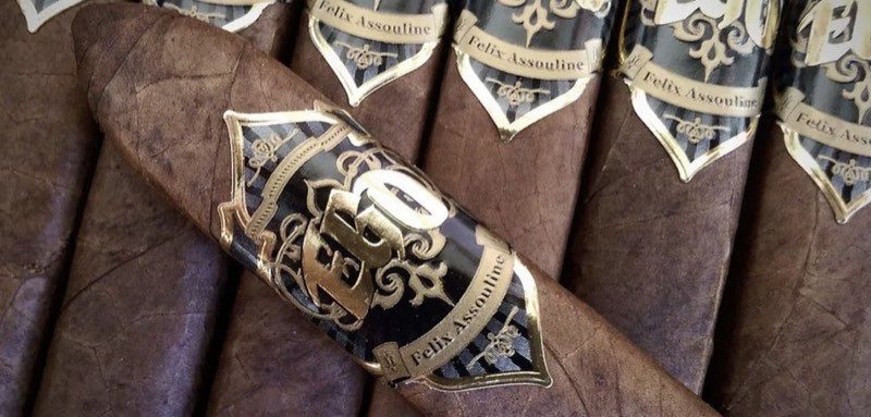 EGO Black cigars side by side, each wearing the black-and-gold Felix Assouline band